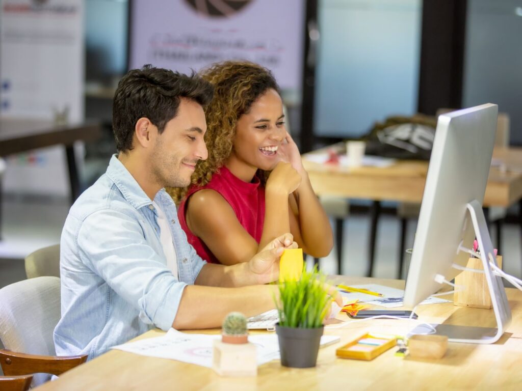 Two colleagues at a B2B marketing agency collaborating on a digital strategy in an office setting.