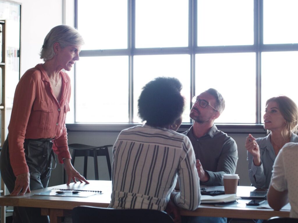Marketing team meeting discussing strategies to improve a website's AI referral traffic and visibility across ChatGPT, Perplexity, and other AI search platforms.
