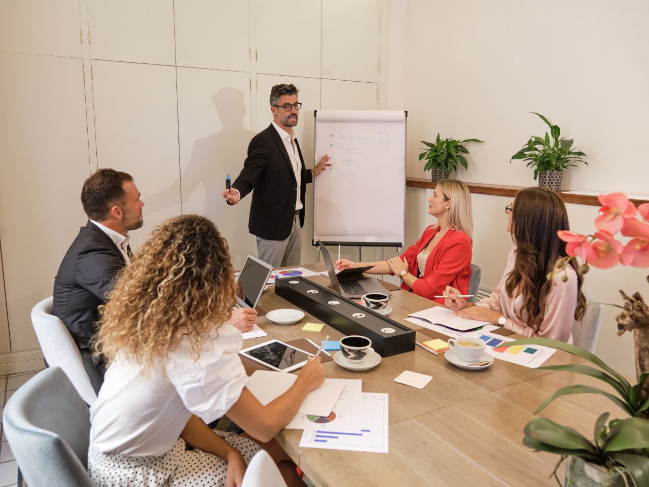 Business professionals discussing whether they should prioritize PPC or SEO for improving lead generation, marketing results, and long-term business growt